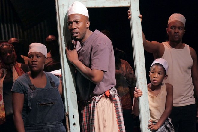 Somali refugee Asad Abdullahi is played by four different actors, each wearing the same white hat: (left to right) Zoleka Mpotsha, Ayanda Tikolo, Siphosethu Juta and Luvo Tamba.